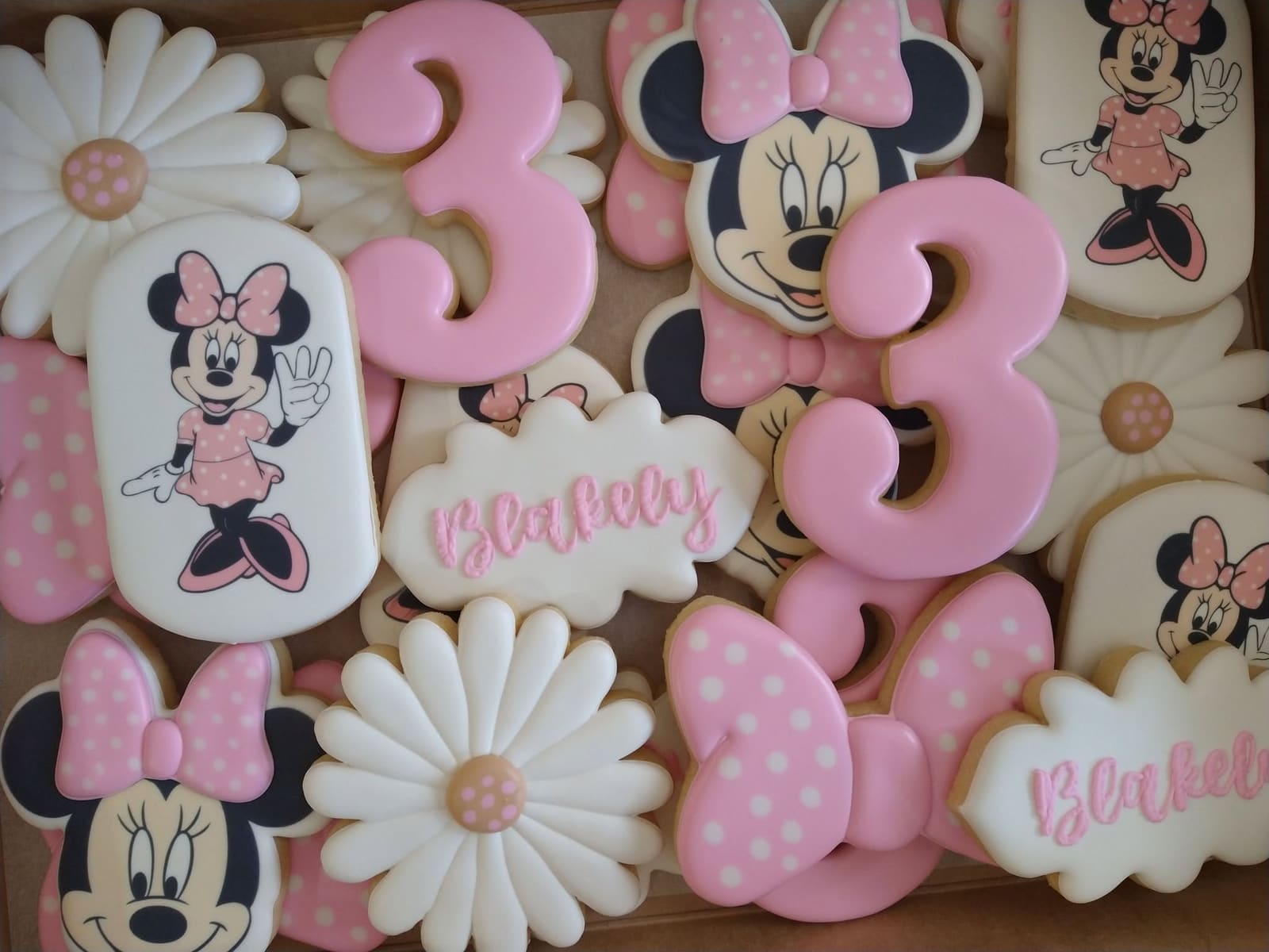 Pink third birthday cookies with polka dot bows, white daisies, character cookies, and number three cookies